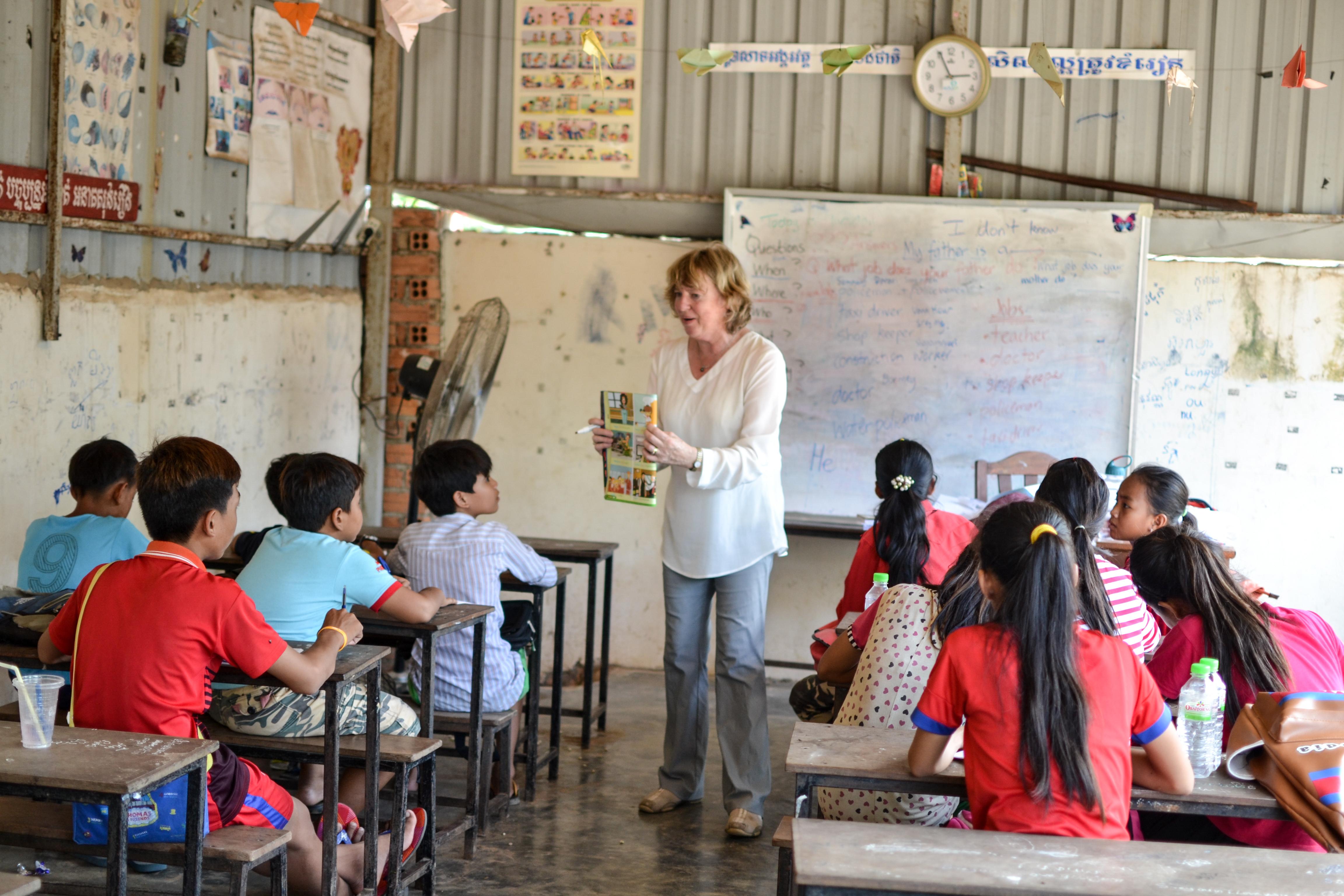 A volunteer English teacher reads a book to her class during her volunteer teaching placement in Cambodia An English book is read to the students by a Projects Abroad volunteer teaching in Cambodia